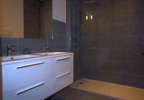 Shared bathroom with large shower and twin basins