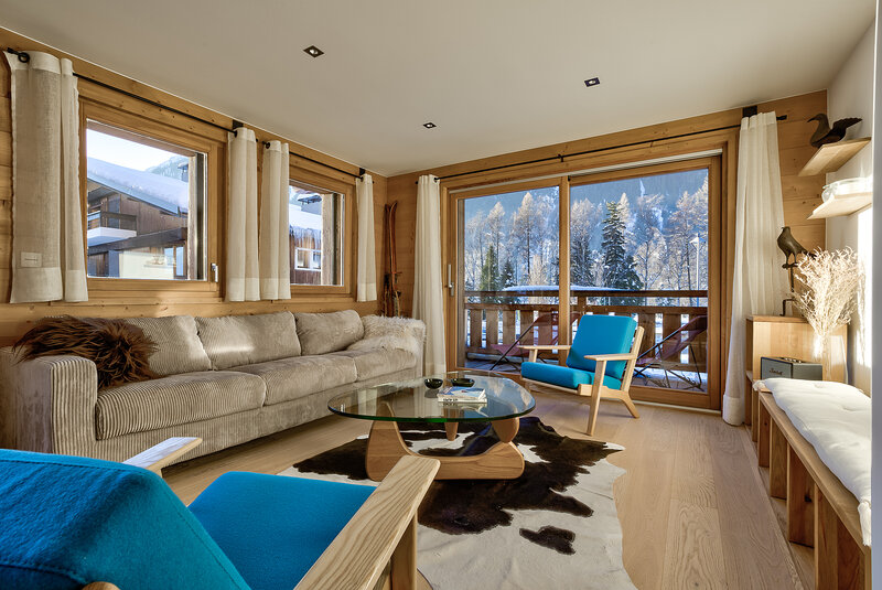 Comfortable sitting area opening onto a balcony with mountain views
